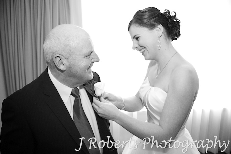 Bride putting father's button hole on - wedding photography sydney